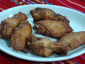 Seis piezas de alitas de pollo fritas, crujientes y deliciosas, sin picante para disfrutar en cualquier momento.