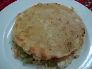 Dos tacos de maíz rellenos de pollo, queso fundido y guacamole fresco, sin picante. ¡Una deliciosa combinación de sabores!